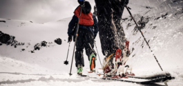 two skiers out walking with skis on doing back country, walking away up into the mountain, away from the camera Ross Woodhall - Action & Lifestyle Photography