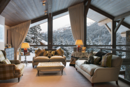 Lounge area with large triangular windows out to the mountains. Ross Woodhall - Action & Lifestyle Photography