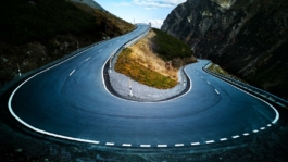Winding road through autumnal trees in the Alps Ross Woodhall - Action & Lifestyle Photography