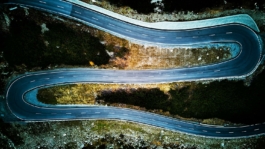 Winding road through autumnal trees in the Alps Ross Woodhall - Action & Lifestyle Photography